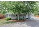 Charming gray home featuring a covered front porch and a mature shade tree at 2565 Pierce St, Lakewood, CO 80214