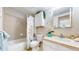 A bright bathroom featuring a tile backsplash, cabinets for storage, and a shower-tub combo with a curtain at 601 W 11Th Ave # 1109, Denver, CO 80204