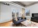 Stylish living room with balcony access, hardwood floors, and comfortable seating arrangement at 1499 Blake St # 3O, Denver, CO 80202