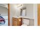 Bathroom featuring a vanity with storage, a toilet, and a mirror at 7208 Secrest Ct, Arvada, CO 80007