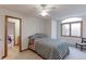 Inviting bedroom with natural light, a bed with patterned bedding, and a door to an ensuite at 7208 Secrest Ct, Arvada, CO 80007