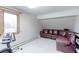 Cozy bonus room with a leather sectional sofa and exercise equipment at 7208 Secrest Ct, Arvada, CO 80007