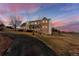Charming two-story home featuring a brick turret under a pink and purple sunset at 7208 Secrest Ct, Arvada, CO 80007