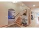 Hallway with staircase, doorway to living room, and decorative table with lamps at 7208 Secrest Ct, Arvada, CO 80007