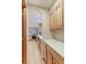 Long kitchen with wood cabinets, white countertops, and stainless steel appliances at 7208 Secrest Ct, Arvada, CO 80007