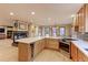 Bright, open-concept kitchen with island seating, stainless appliances, and a wine fridge at 7208 Secrest Ct, Arvada, CO 80007