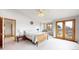 Comfortable bedroom features neutral decor, natural light, and balcony access at 7208 Secrest Ct, Arvada, CO 80007