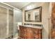Bathroom features a large vanity with elegant sink, framed mirror and tiled glass shower at 8426 Cook Way, Denver, CO 80229