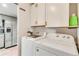 Functional laundry room with white appliances, cabinets, and easy access to adjacent kitchen at 8426 Cook Way, Denver, CO 80229