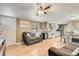 Living area that is open to the kitchen features wood grain floors and warm colors at 8426 Cook Way, Denver, CO 80229