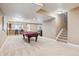 This open-concept basement features a billiards table, a bar, and stairs to the upper level at 6711 S Catawba Way, Aurora, CO 80016