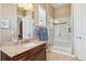 Bright bathroom featuring granite countertop vanity, a sink, and glass-enclosed shower with tiled bench at 6711 S Catawba Way, Aurora, CO 80016