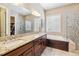 This bathroom features a double sink vanity, a soaking tub, and a glass-enclosed shower at 6711 S Catawba Way, Aurora, CO 80016
