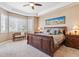 Comfortable primary bedroom with a ceiling fan, large windows, and a sitting bench to enjoy the view at 6711 S Catawba Way, Aurora, CO 80016