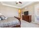 This main bedroom features a ceiling fan, a dresser with a TV, and a door to a balcony at 6711 S Catawba Way, Aurora, CO 80016