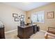 Dedicated home office with a large executive desk and natural light from the window at 6711 S Catawba Way, Aurora, CO 80016