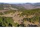 Expansive aerial shot showcasing a beautiful log home surrounded by lush forest and mountain vistas at 280 Hess Ave, Golden, CO 80401