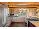 Well-lit kitchen featuring stainless steel appliances, wood cabinets, and granite countertops at 280 Hess Ave, Golden, CO 80401