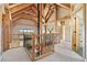 Open loft area with exposed wood beams, iron railing and views of the surrounding landscape at 280 Hess Ave, Golden, CO 80401
