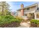Charming home featuring a brick chimney, gray siding, and lush landscaping at 93 S Nome St, Aurora, CO 80012
