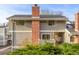 Exterior of townhome featuring a brick chimney and landscaping at 93 S Nome St, Aurora, CO 80012