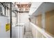 Laundry room with washer, dryer, shelving, and exposed pipes at 93 S Nome St, Aurora, CO 80012