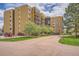 Well-kept apartment building exterior with green space, mature trees, and parking at 14152 E Linvale Pl # 509, Aurora, CO 80014