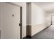 Hallway leading to the apartment door with neutral paint and carpet at 14152 E Linvale Pl # 509, Aurora, CO 80014