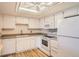 Bright kitchen featuring white cabinets, wooden floor and white appliances at 14152 E Linvale Pl # 509, Aurora, CO 80014
