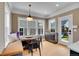 Bright breakfast nook with built-in seating, round table, and many windows overlooking the backyard at 3212 Fulton St, Denver, CO 80238