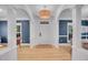 Bright and airy foyer with white columns, light hardwood floors, elegant lighting, and a view to the dining room at 3212 Fulton St, Denver, CO 80238