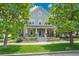 Charming two-story home with light-green siding, inviting front porch, and professionally landscaped front yard at 3212 Fulton St, Denver, CO 80238