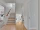 Well-lit hallway featuring wood floors, a staircase, and several doorways leading to other rooms in the home at 3212 Fulton St, Denver, CO 80238