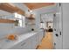 Bright white kitchen with marble countertops, stainless steel appliances, floating shelves, and hardwood floors at 3212 Fulton St, Denver, CO 80238