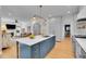 Bright kitchen with marble countertops, island with seating, brass fixtures, and open to the living room at 3212 Fulton St, Denver, CO 80238