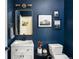 Stylish bathroom with navy walls, a modern vanity, and decorative gold mirror at 3567 E 140Th Dr, Thornton, CO 80602