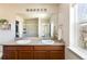 Bright bathroom features a double vanity, granite countertops, and a large mirror at 3567 E 140Th Dr, Thornton, CO 80602