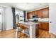 Kitchen island features stainless steel appliances, seating, and hardwood floors at 3567 E 140Th Dr, Thornton, CO 80602