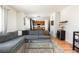 Open-concept living area featuring a large sectional sofa, hardwood floors, and a modern bar at 3567 E 140Th Dr, Thornton, CO 80602