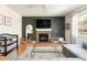 Cozy living room featuring a brick fireplace, dark accent wall, and hardwood floors at 3567 E 140Th Dr, Thornton, CO 80602
