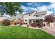 Landscaped backyard featuring a well-manicured lawn, a patio with outdoor furniture, and a view of the home's exterior at 10245 Nottingham Dr, Parker, CO 80134