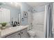 Clean bathroom featuring modern fixtures, including a sink, toilet, and shower with white tile and blue painted walls at 10245 Nottingham Dr, Parker, CO 80134