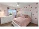 Bedroom with pink walls, a flower motif, and neutral furniture at 10245 Nottingham Dr, Parker, CO 80134
