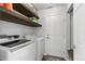 Laundry room with modern appliances and open shelving at 10245 Nottingham Dr, Parker, CO 80134