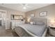 Well-lit main bedroom featuring neutral tones, a large dresser, and a comfortable bed with a tufted headboard at 10245 Nottingham Dr, Parker, CO 80134