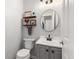 Stylish powder room with modern fixtures, floating shelves, and round mirror at 10245 Nottingham Dr, Parker, CO 80134