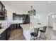 Well-lit kitchen featuring dark cabinets, granite counters, and island with seating at 5188 Andes Way, Denver, CO 80249