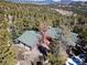 An aerial shot shows the home with mountain views and lots of trees at 11540 Inspiration Rd, Golden, CO 80403