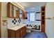 Bathroom with wood cabinets, blue carpeting, a tub, and natural lighting at 11540 Inspiration Rd, Golden, CO 80403