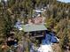 Exterior of the mountain home featuring mature pine trees and a cozy deck at 11540 Inspiration Rd, Golden, CO 80403